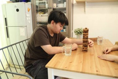 Güneydoğu Asyalı çocuk annesiyle tahta kule oyunu oynuyor..