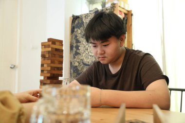 Güneydoğu Asyalı çocuk annesiyle tahta kule oyunu oynuyor..