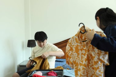 Güneydoğu Asya 'lı bekar anne, genç oğlunun bavullarını toplamasına yardım ediyor..