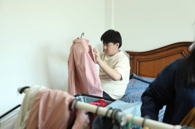 Güneydoğu Asya 'lı bekar anne, genç oğlunun bavullarını toplamasına yardım ediyor..