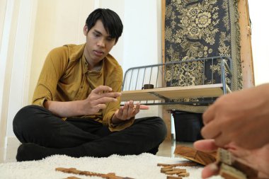 Güneydoğu Asyalı adam arkadaşlarıyla domino oynuyor..