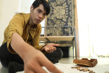 Güneydoğu Asyalı adam arkadaşlarıyla domino oynuyor..