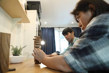 Güneydoğu Asyalı adam arkadaşlarıyla Jenga masa oyunu oynuyor...