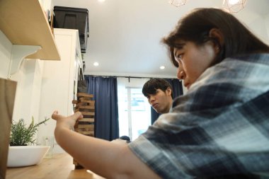 Güneydoğu Asyalı adam arkadaşlarıyla Jenga masa oyunu oynuyor...