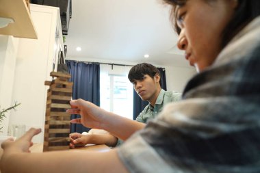 Güneydoğu Asyalı adam arkadaşlarıyla Jenga masa oyunu oynuyor...