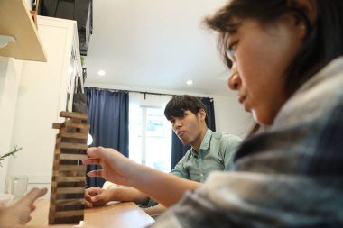 Güneydoğu Asyalı adam arkadaşlarıyla Jenga masa oyunu oynuyor...