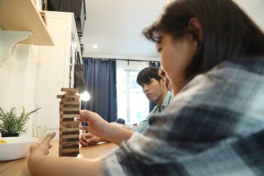 Güneydoğu Asyalı adam arkadaşlarıyla Jenga masa oyunu oynuyor...