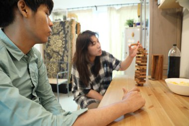 Güneydoğu Asyalı adam arkadaşlarıyla Jenga masa oyunu oynuyor...