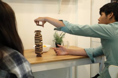 Güneydoğu Asyalı adam arkadaşlarıyla Jenga masa oyunu oynuyor...