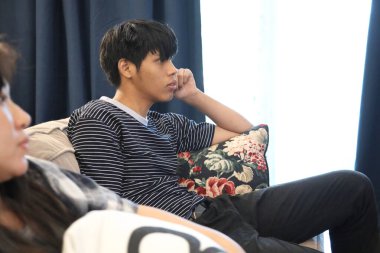 İki Güneydoğu Asyalı arkadaş evde film izliyorlar..