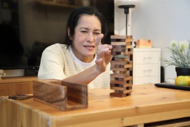 Güneydoğu Asyalı çocuk annesiyle tahta kule oyunu oynuyor..