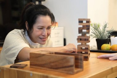 Güneydoğu Asyalı çocuk annesiyle tahta kule oyunu oynuyor..