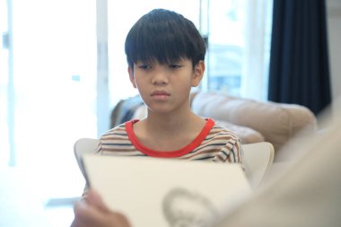 Güneydoğu Asya 'lı bekar anne oğlunun hareketsiz otururken resmini çiziyor..