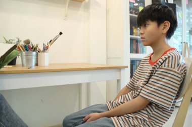 Güneydoğu Asya 'lı bekar anne oğlunun hareketsiz otururken resmini çiziyor..