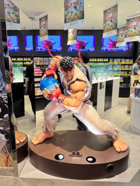 Tokyo, Japonya - 24 Mayıs 2025: Tokyo, Shibuya 'daki Capcom mağazasının önünde Japon bir Street Fighter karakterinin heykeli duruyor. İkonik dövüş oyunları dizisinin hayranları için popüler bir fotoğraf noktası.