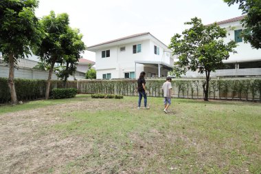 Güneydoğu Asya 'lı bekar bir anne çocuğuyla parkta vakit geçirir ve bitki, böcek ve doğal çevre gibi doğa temelli öğrenme faaliyetleriyle ilgilenir..