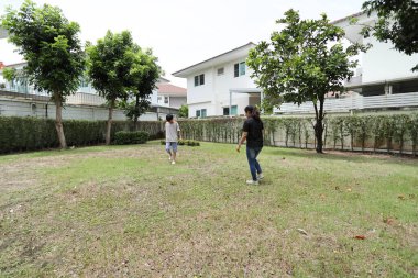 Güneydoğu Asya 'lı bekar bir anne çocuğuyla parkta vakit geçirir ve bitki, böcek ve doğal çevre gibi doğa temelli öğrenme faaliyetleriyle ilgilenir..