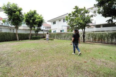 Güneydoğu Asya 'lı bekar bir anne çocuğuyla parkta vakit geçirir ve bitki, böcek ve doğal çevre gibi doğa temelli öğrenme faaliyetleriyle ilgilenir..