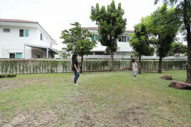 Güneydoğu Asya 'lı bekar bir anne çocuğuyla parkta vakit geçirir ve bitki, böcek ve doğal çevre gibi doğa temelli öğrenme faaliyetleriyle ilgilenir..