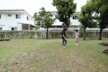 Güneydoğu Asya 'lı bekar bir anne çocuğuyla parkta vakit geçirir ve bitki, böcek ve doğal çevre gibi doğa temelli öğrenme faaliyetleriyle ilgilenir..