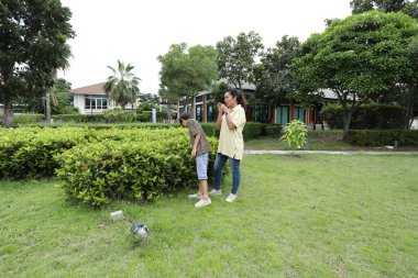 Güneydoğu Asya 'lı bekar bir anne çocuğuyla parkta vakit geçirir ve bitki, böcek ve doğal çevre gibi doğa temelli öğrenme faaliyetleriyle ilgilenir..