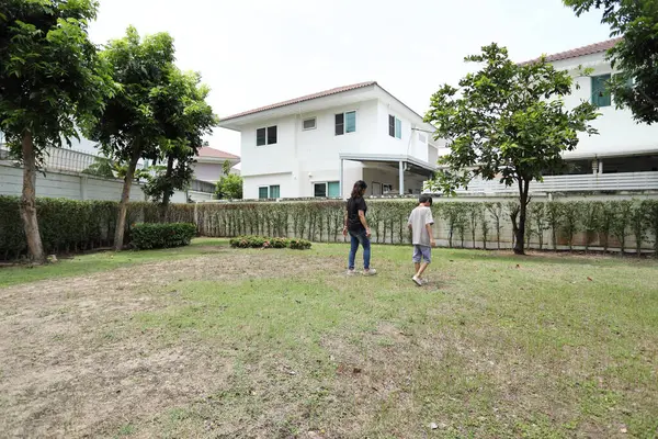 Güneydoğu Asya 'lı bekar bir anne çocuğuyla parkta vakit geçirir ve bitki, böcek ve doğal çevre gibi doğa temelli öğrenme faaliyetleriyle ilgilenir..