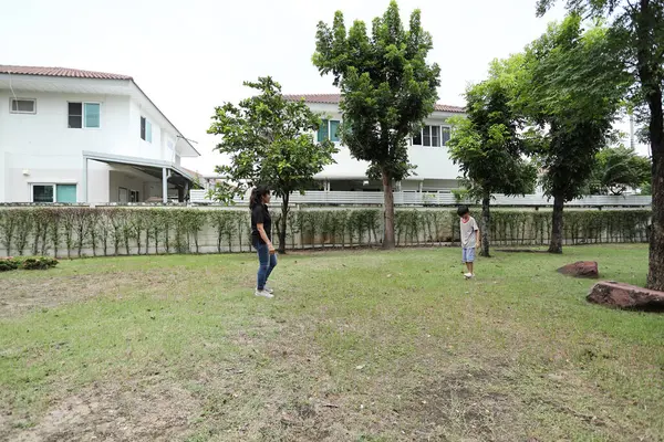 Güneydoğu Asya 'lı bekar bir anne çocuğuyla parkta vakit geçirir ve bitki, böcek ve doğal çevre gibi doğa temelli öğrenme faaliyetleriyle ilgilenir..