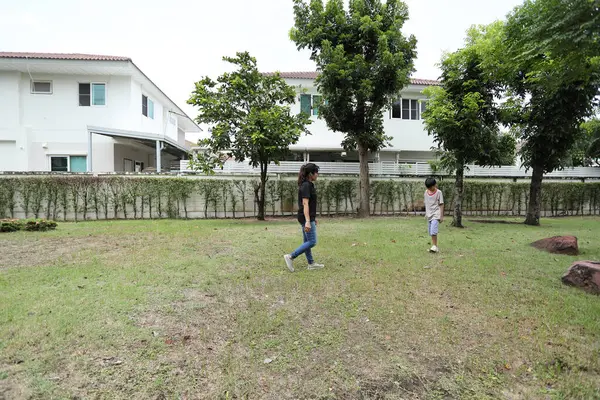 Güneydoğu Asya 'lı bekar bir anne çocuğuyla parkta vakit geçirir ve bitki, böcek ve doğal çevre gibi doğa temelli öğrenme faaliyetleriyle ilgilenir..
