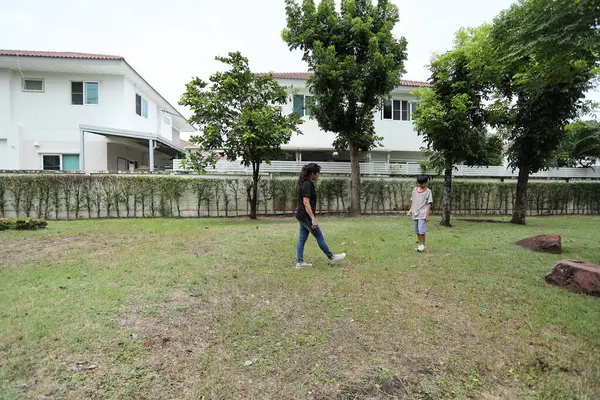 Güneydoğu Asya 'lı bekar bir anne çocuğuyla parkta vakit geçirir ve bitki, böcek ve doğal çevre gibi doğa temelli öğrenme faaliyetleriyle ilgilenir..