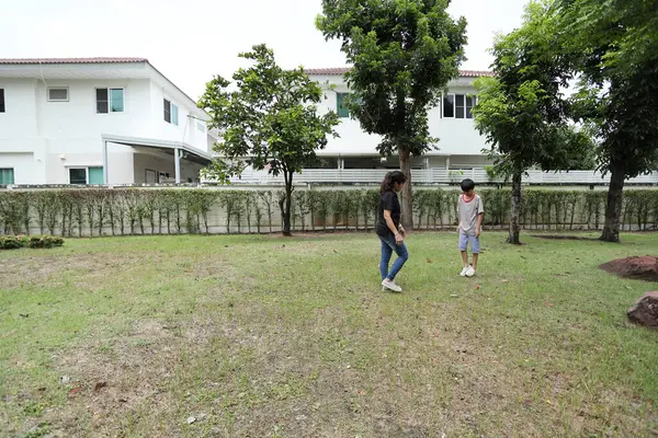 Güneydoğu Asya 'lı bekar bir anne çocuğuyla parkta vakit geçirir ve bitki, böcek ve doğal çevre gibi doğa temelli öğrenme faaliyetleriyle ilgilenir..