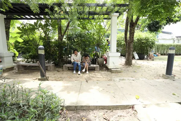 Güneydoğu Asya 'lı bekar bir anne çocuğuyla parkta vakit geçirir ve bitki, böcek ve doğal çevre gibi doğa temelli öğrenme faaliyetleriyle ilgilenir..