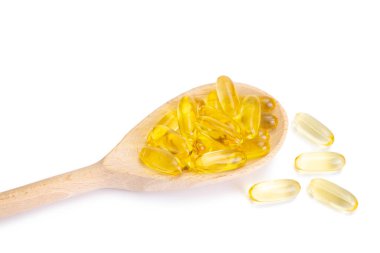 Beyaz arka planda izole edilmiş tahta kaşıkta Omega 3 kapsülü yığını. Yumuşak jeller, cilt için tabletler, sağlık, hastalık tedavisi. Sağlık, diyet, kalp kardiyovasküler destek, cilt bakımı, eczane