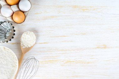 Baking cooking Ingredients background with copy space. Flour, eggs, milk, bakeware on white wooden surface. Top view, flat lay. Mockup menu, banner, header for site, baking concept