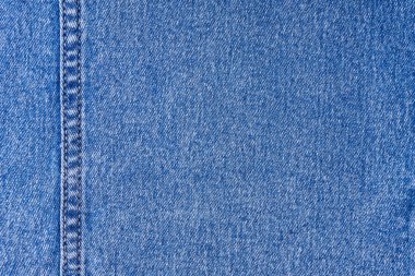 Denim kot kumaş arka planı. Dekoratif dikişli mavi renkli pamuk dokusu. Dikiş desenli kot arka plan. İplik ve kumaş yapısı. Duvar kağıdı, afiş, arkaplan, başlık