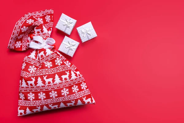 赤い背景にクリスマス柄の装飾クリスマスギフトボックスと赤いギフトバッグ フラットレイアウト トップビュー バナー ヘッダー コピースペースとモックアップ グリーティングカードのテンプレート — ストック写真