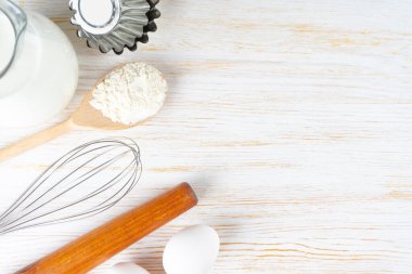 Baking cooking Ingredients background with copy space. Flour, eggs, milk, bakeware on white wooden surface. Top view, flat lay. Mockup menu, banner, header for site, baking concept