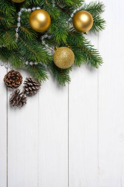 Altın toplarla süslenmiş Noel ağacı dalı ve beyaz ahşap arka planda hediye kutusu. Üst görünüm, kopya alanı ile düz uzanma, Yeni Yıl arkaplanı, dikey yönelim