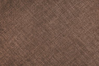 Jacquard woven upholstery, brown coarse fabric texture with diagonal weave lines. Textile background, furniture textile material, wallpaper, backdrop. Cloth structure close up.