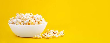 Sarı arka planda izole edilmiş kasedeki lezzetli peynirli patlamış mısır. Metin için kopyalama alanı olan duvar kağıdı, afiş, başlık