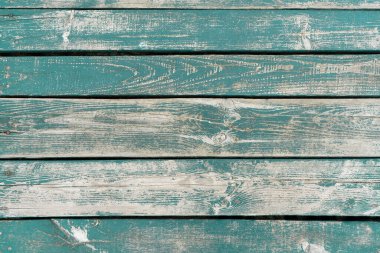 Wooden background. Old turquoise painted wooden plank surface, aged weathered cracked boards. Grunge shabby texture.