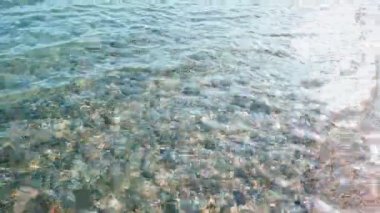 Havuz suyu dalgalanmaları ve güneşin yansıması. Dalgalar, gök mavisi deniz hareketleri, güneş ışınlı okyanus suyu. Su soyut arka plan. Yüksek kaliteli FullHD görüntüler