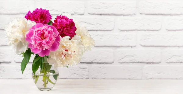 花瓶中的粉红色和白色牡丹花在白色砖墙的背景下 假期模板 母亲节 带有复制空间的头 — 图库照片