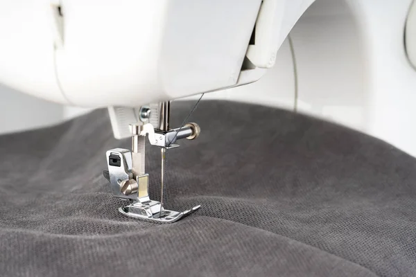 グレーの生地と糸で現代のミシンプレス足 クローズアップ 縫製プロセス服 カーテン ビジネス 手作り 廃棄物ゼロ リサイクル 修理の概念 — ストック写真