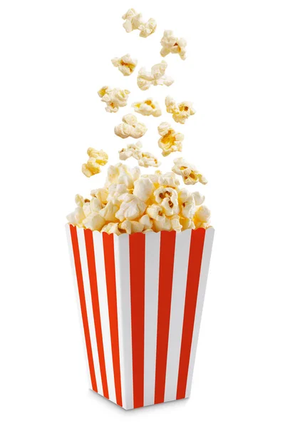 Kırmızı çizgili karton kutudan fırlayan patlamış mısır beyaz arka planda izole edilmiş ve kopyalanmış. Sıçrama, patlamış mısır tanelerinin havaya kaldırılması..