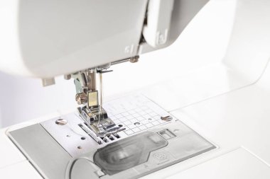 Modern beyaz dikiş makinesi presör ayak yakın çekim, makro. Dikiş ekipmanları, atölye işi, imalat, meslek için çalışma aracı.