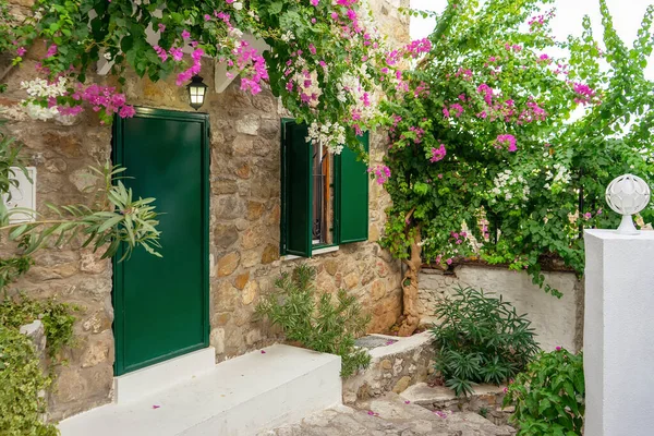 Eski bir kasabada, begonvillerin açtığı pembe çiçekli eski bir tuğla evin güzel avlusu. Seyahat, tatil konsepti. Avrupa mimarisi