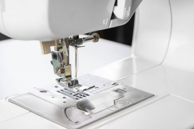 Modern beyaz dikiş makinesi presör ayak yakın çekim, makro. Dikiş ekipmanları, atölye işi, imalat, meslek için çalışma aracı.