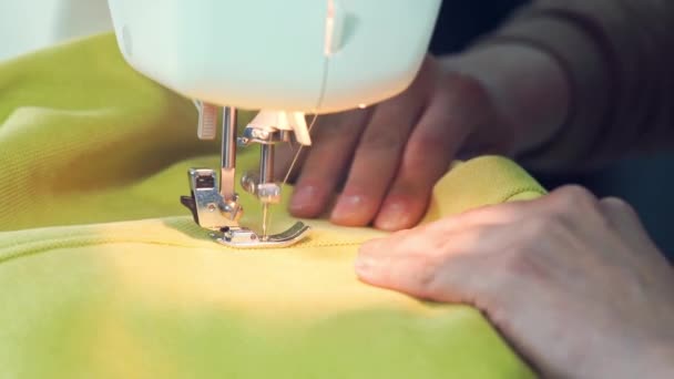 足を押し ミシン針を動かし 布を縫う 縫い目は現代のミシンの縫製ワークショップで黄色の生地を縫う プロ仕様機器 — ストック動画