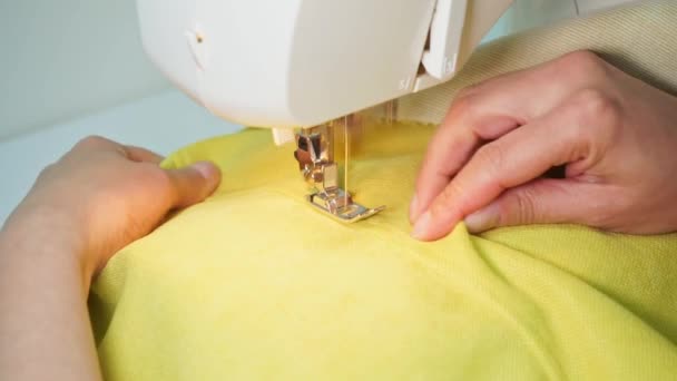 足を押し ミシン針を動かし 布を縫う 縫い目は現代のミシンの縫製ワークショップで黄色の生地を縫う プロ仕様機器 — ストック動画