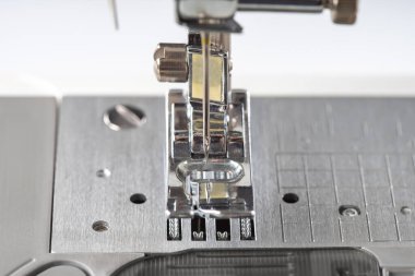 Modern beyaz dikiş makinesi presör ayak yakın çekim, makro. Dikiş ekipmanları, atölye işi, imalat, meslek için çalışma aracı.